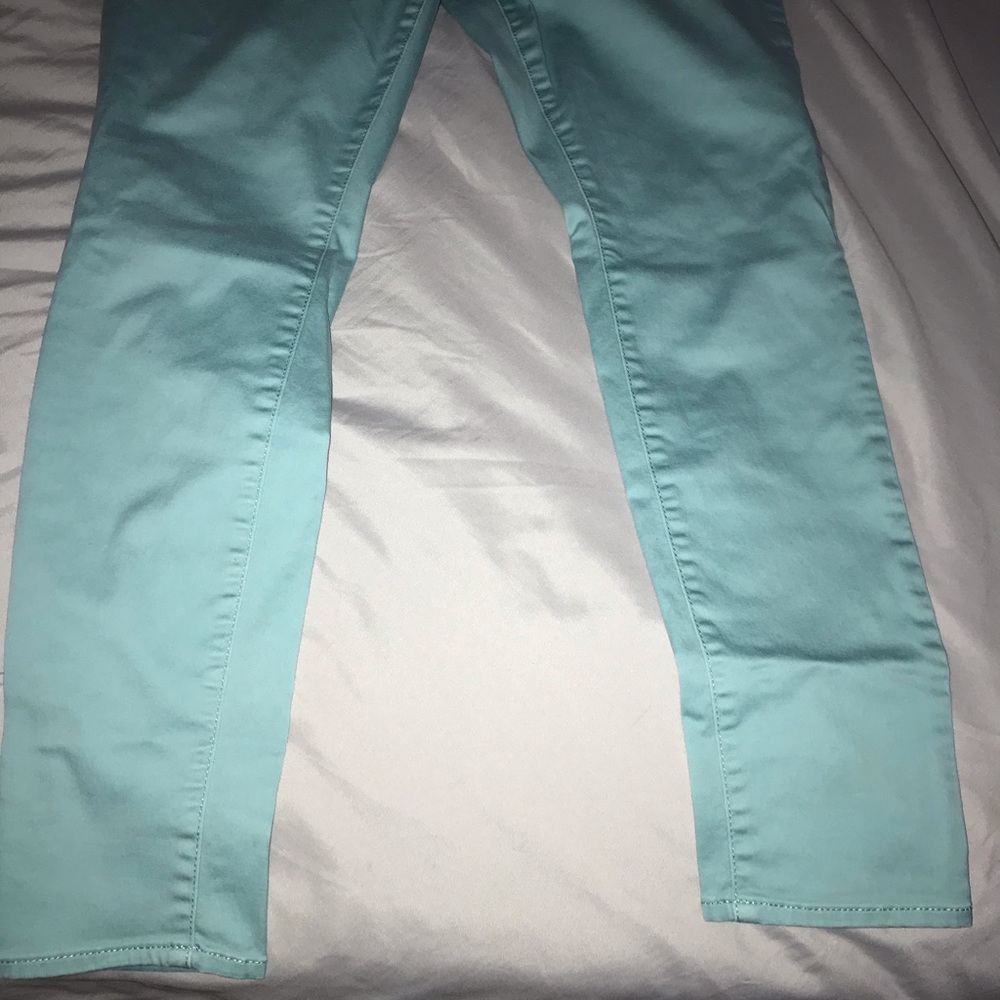 Made in Indonesia. Color is mint green. Three buttons in front and back pockets